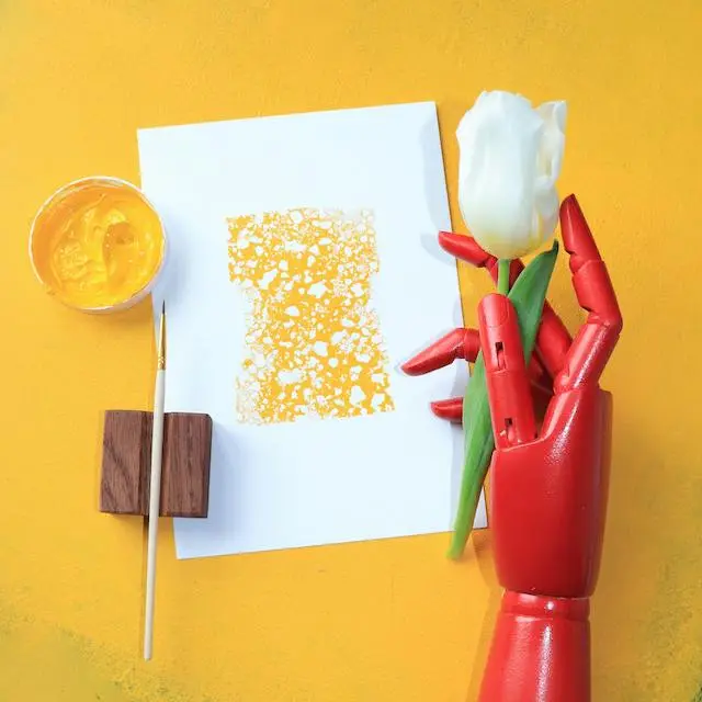 Robotic hand reaching toward a colorful painting, symbolizing artificial intelligence and creativity.