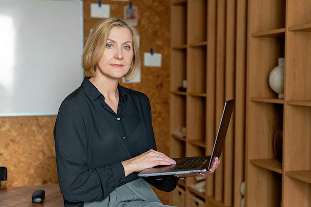 Woman holding a laptop representing the human-in-the-loop approach of Manus AI technology